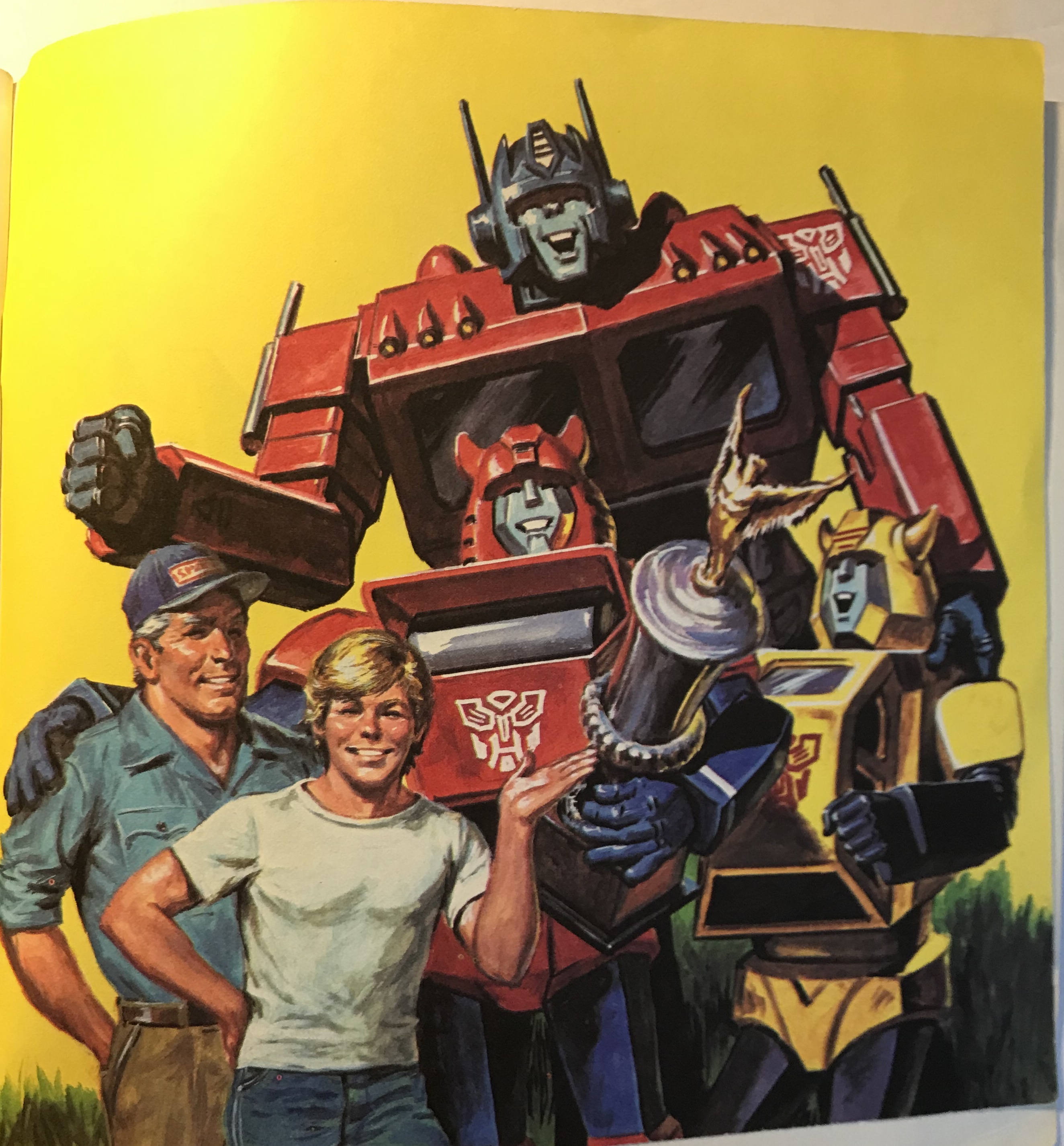 Optimus, Bumblebee, Cliffjumper, Spike and Sparkplug standing with a trophy